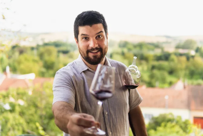 Jaromír nabízí sklenku červeného ve vinici